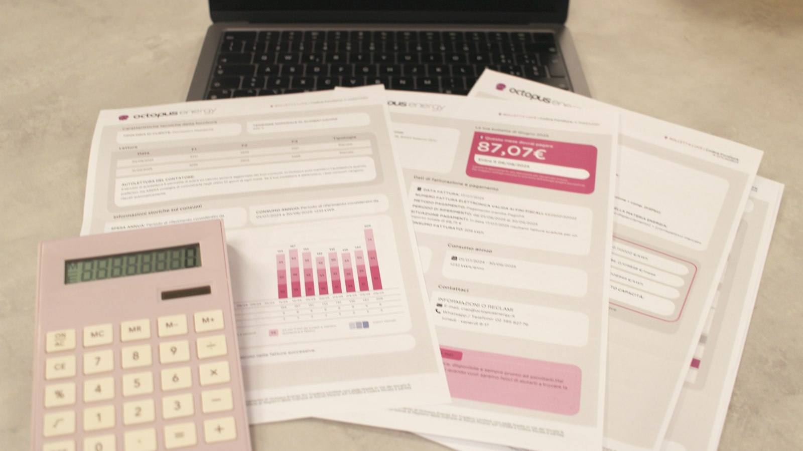 Factures papier, calculatrice et ordinateur portable sur un bureau